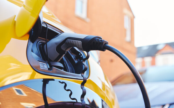 Electric car charging outside house on street