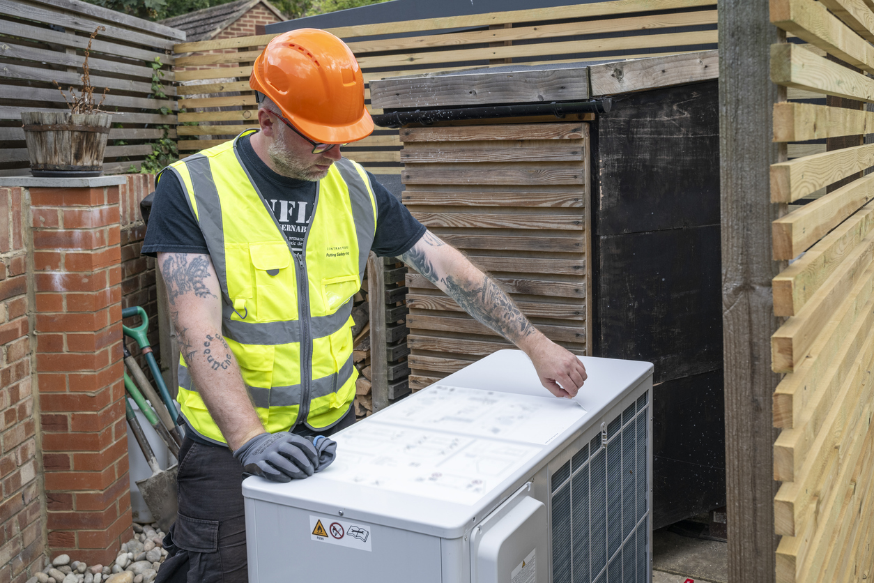 Man installing air source heat pump