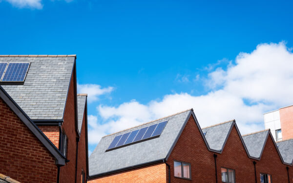 Houses with solar panels under blue sky