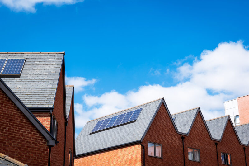 Houses with solar panels under blue sky