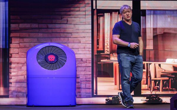 Man presenting next to purple heat pump.