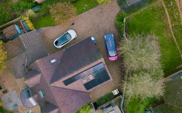 Aerial view of a residential property with solar install and EV car.