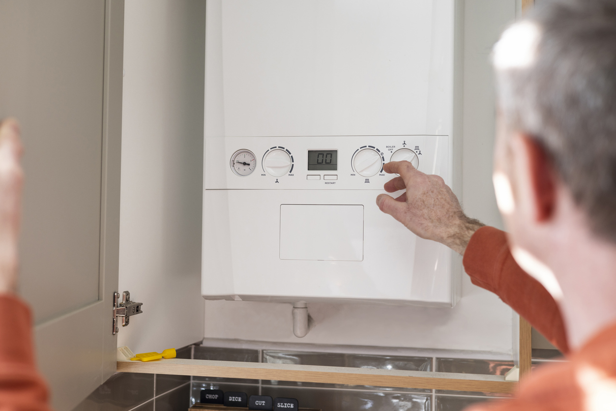 Man adjusting a boiler's settings.