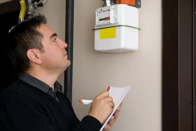 Man reading gas meter, taking notes