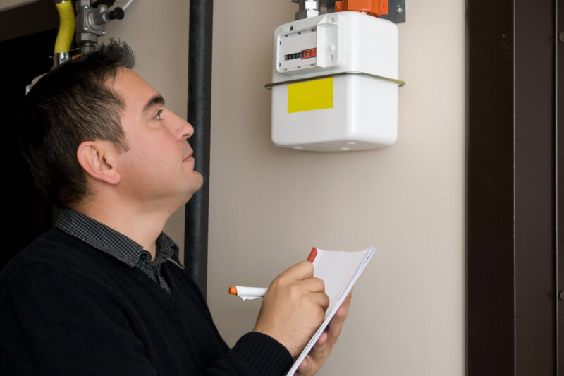 Man reading gas meter, taking notes